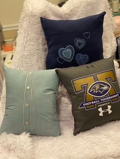 three pillows sitting on top of a white chair next to a pillow case with the words football tournament written on it