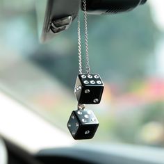 two black dice hanging from the side of a car