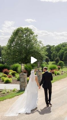 a bride and groom walking down the road