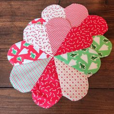 several pieces of fabric sitting on top of a wooden table with one piece cut out to look like hearts