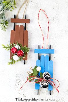 two popsicle sled ornaments are hanging on the wall