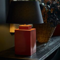 a red lamp sitting on top of a wooden table