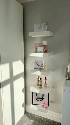 a white shelf filled with cosmetics and perfume bottles