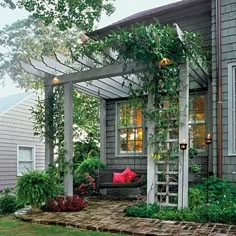 a house with a porch covered in plants and flowers