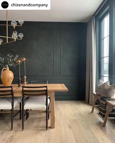 a dining room with black walls and wooden floors