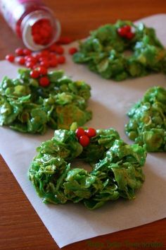 christmas wreath shaped cookies sitting on top of a table