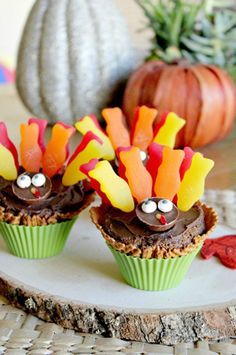 three cupcakes decorated like turkeys on a plate