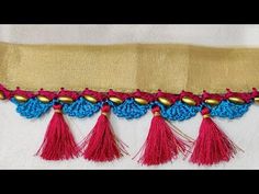 three tassels are attached to the side of a piece of cloth with gold and red trim