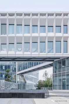 the entrance to an office building with many windows and steps leading up to it's entrance