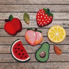 fruit appliques are arranged on a wooden surface