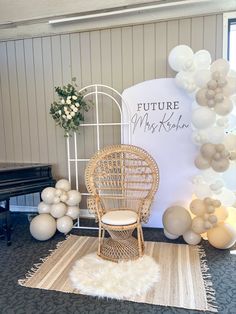 a chair and balloon arch in front of a sign