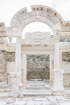 an arch in the middle of a stone building with columns and arches on either side