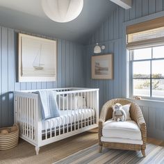 a baby's room with blue walls and white furniture