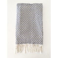 a blue and white blanket with fringes on it