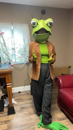 a person in a frog costume standing next to a couch