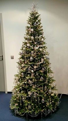 a decorated christmas tree in an office cubicle with blue carpeting and white walls