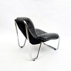 a black leather chair sitting on top of a metal frame base with a white background