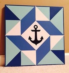 an anchor is painted on the side of a blue and white tile wall with geometric shapes