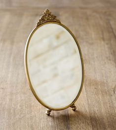 a small mirror sitting on top of a wooden table