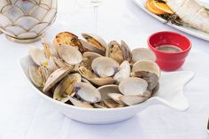 a bowl of clams on a white table cloth