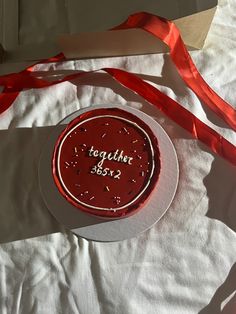 a birthday cake with red frosting and sprinkles on it sitting on a table