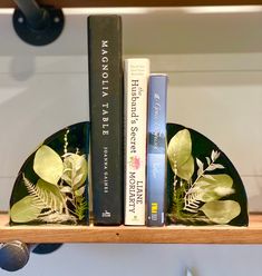 two books are sitting on a shelf next to each other, and there is also a bookend