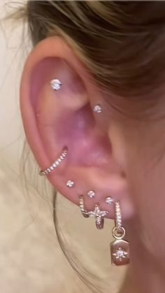 a close up of a person's ear with some piercings on top of it