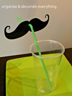 a moustache straw in a plastic cup on a green place mat with the words organize & decorate everything