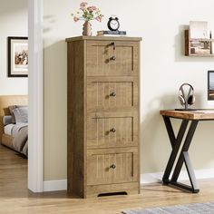 a wooden chest of drawers next to a table with a vase on top of it