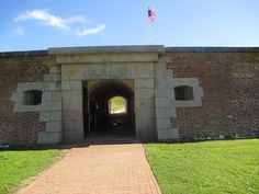 the entrance to an old brick tunnel on a sunny day