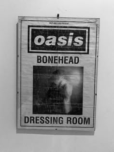 a sign hanging on the side of a wall that says oasis bonehead dressing room