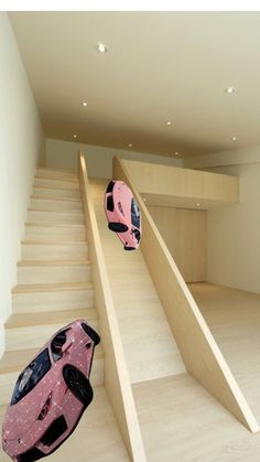 two suitcases are sitting on the floor in front of some stairs with pink cars