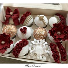 a box filled with cupcakes covered in red and white frosting