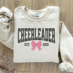 Stay cozy and stylish while showing off your love for cheer with our "Cheerleader" Sweatshirt featuring a Coquette Bow! 🎀 This warm and trendy sweatshirt is perfect for every cheerleader who wants to blend comfort with style. Featuring the word "Cheerleader" paired with a cute coquette bow, this sweatshirt is the ideal way to celebrate your passion for cheer with a touch of elegance. 🎨 Vibrant and Trendy Colors: Available in a variety of fashionable colors, this sweatshirt is designed to match Cheerleader Sweatshirts, Cheer Crewneck Design, Cheer Sweatshirts, Cheer Sweatshirts Design, Cheer Gear, Cheerleading Shirts, Cheerleading Gifts, Cheer Girl, Pom Pom Girl