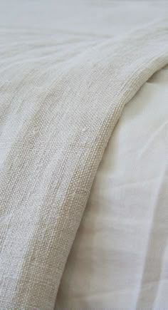 an unmade bed with white sheets and pillows