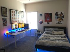 a bed room with a neatly made bed and two computer monitors on the desks