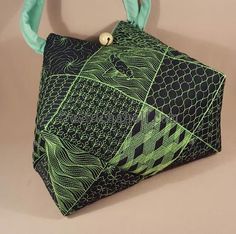 a green and black handbag hanging on a wall