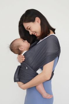 a woman holding a baby in a sling