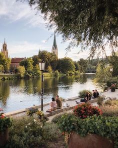 people are sitting on the edge of a river