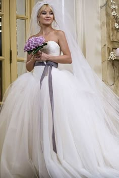 a woman in a wedding dress holding flowers