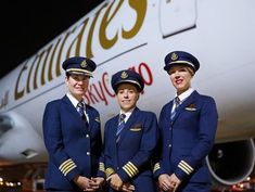 three cabin crew members standing in front of an airplane