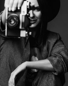 a woman wearing a hat and holding a camera