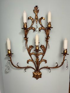 a wall mounted candle holder with four candles