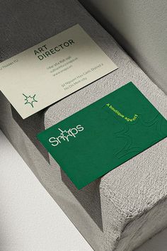 a green business card sitting on top of a concrete block