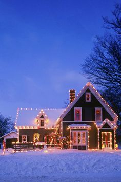 a house covered in christmas lights on a snowy day