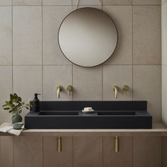 a bathroom sink with a mirror above it and two faucets on the counter