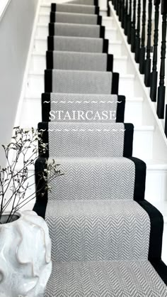 the stairs are lined with black and white carpet