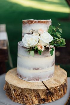 a wedding cake with white flowers on top and pink peonies in the bottom