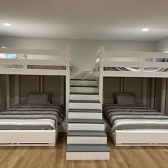 there are two bunk beds in the room with stairs leading up to each bed and another one on the floor