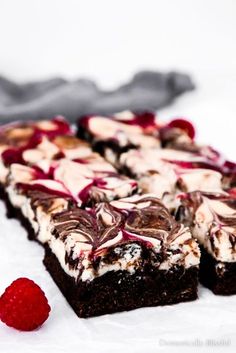 some brownies with white chocolate and raspberry toppings are on the table